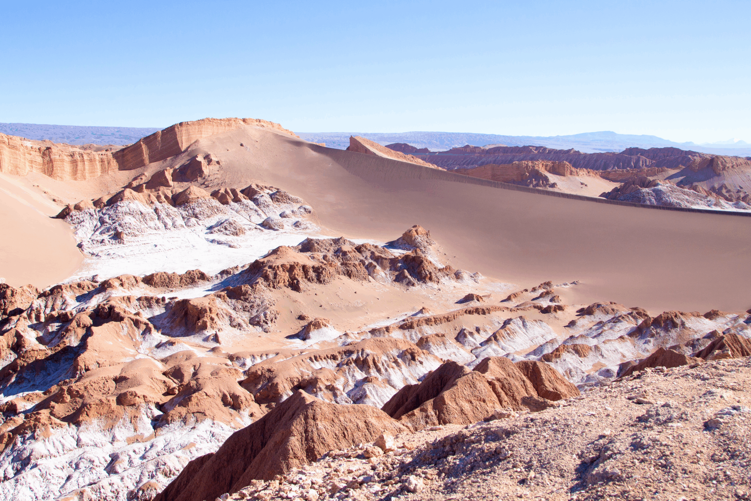 fotografía de dunas de arena fina y formaciones rocosas en el valle de la luna, san pedro de atacama.