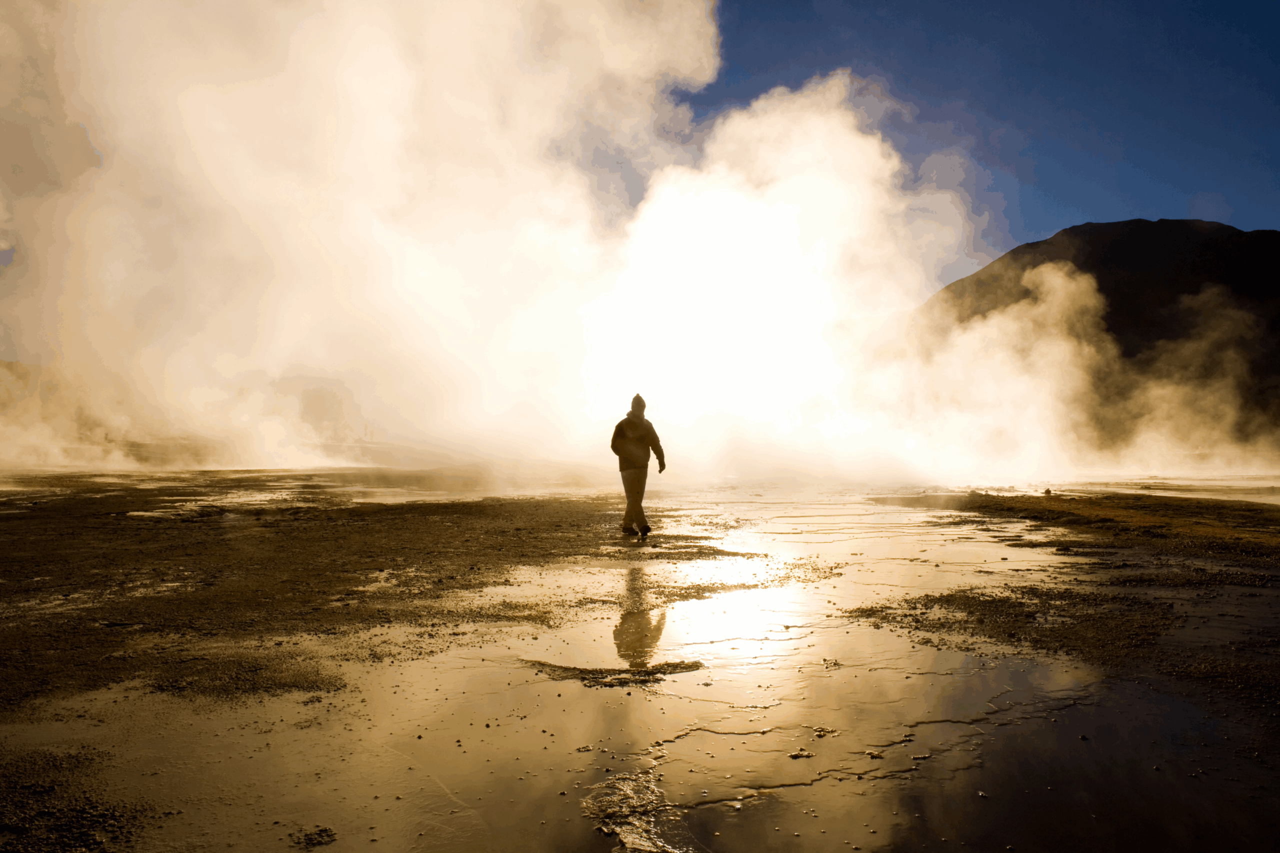 imagen de una persona (silueta) frente a una gran fumarola en los geyser del tatio