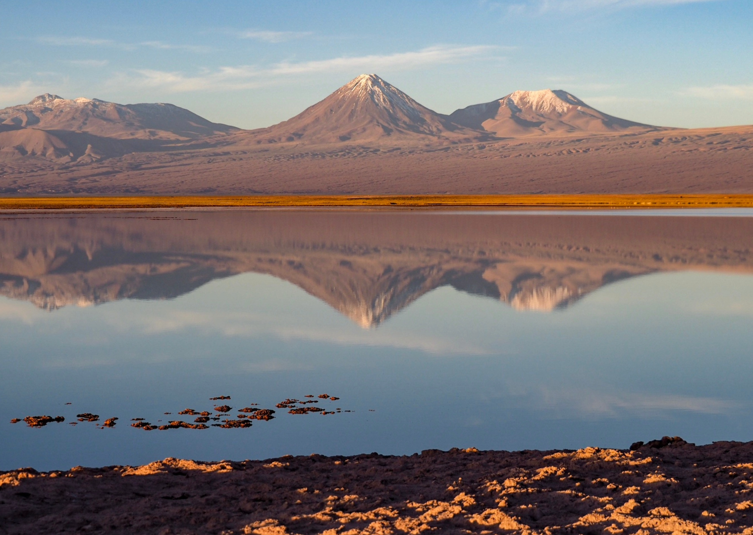 Perfecto reflejo de volcanes en las aguas tranquias de la Laguna Cejar, en San Pedro de Atacama.