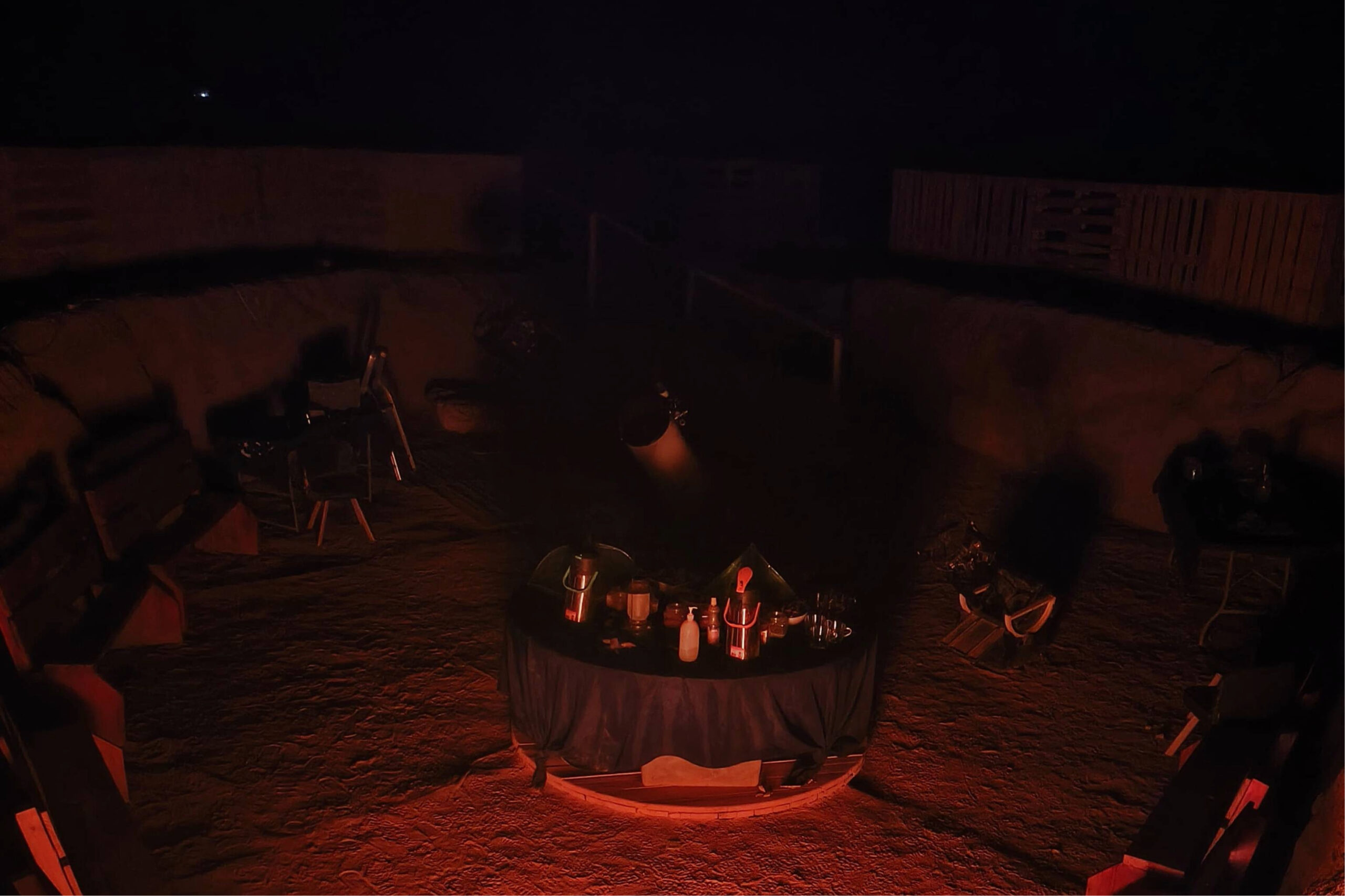 fotografia de una mesa con bebidas calientes, comida tipo picoteo y coctel con telescopios de fondo. Se trata de un punto de observación del cielo estrellado para tours astronómicos en san Pedro de Atacama.